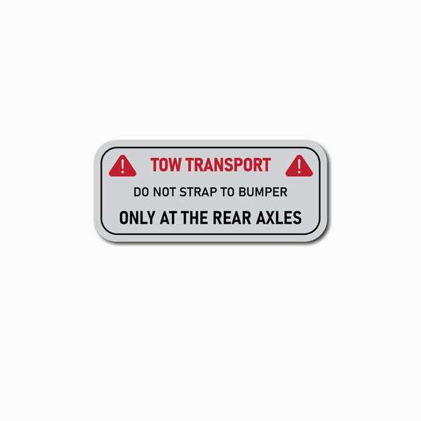 Warning label for tow transport on a white background